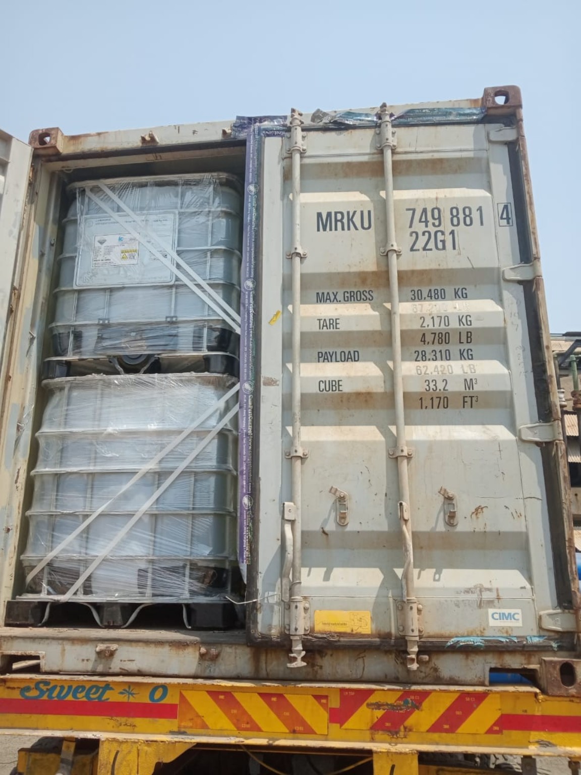 Secured bulk containers loaded in a shipping container on a truck